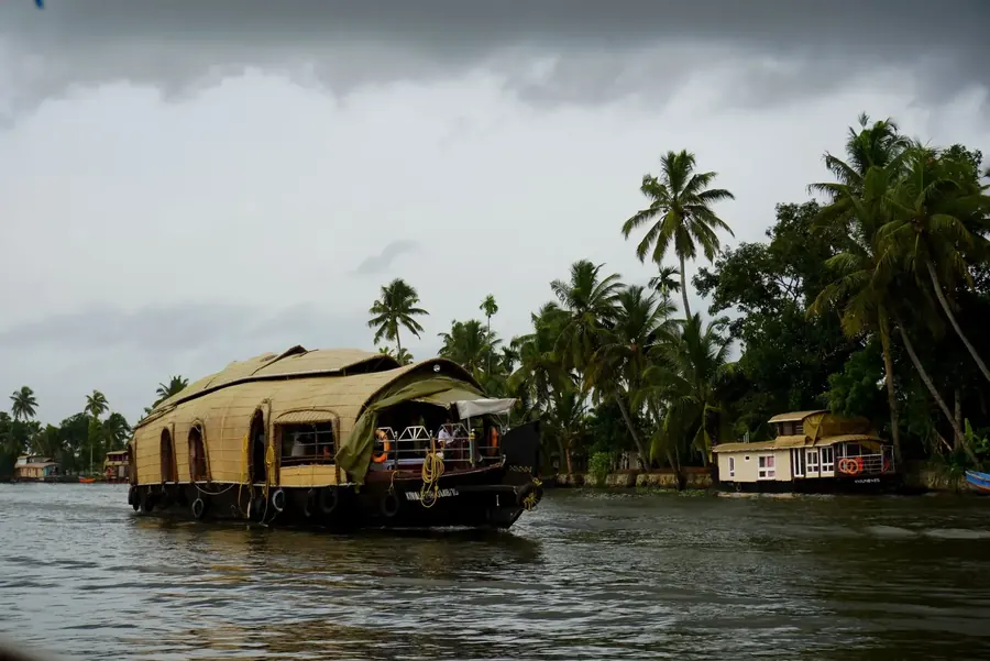 Kerala Alleppey backwaters, traditional wooden houseboat, coconut palm reflections, lush green landscape