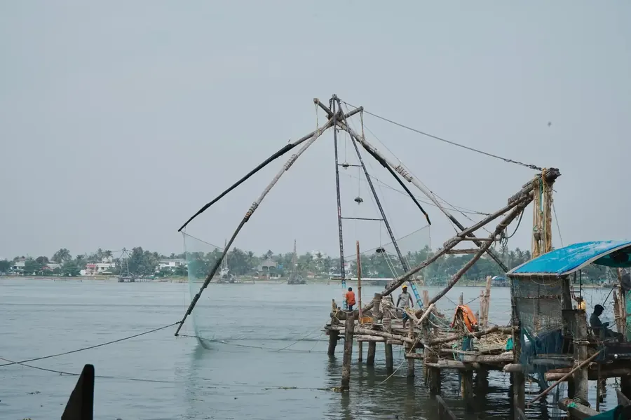 Fort Kochi Chinese fishing nets at sunset, colonial architecture, waterfront, Kerala, warm golden light
