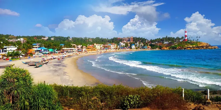 The crescent sweep of Kovalam beach with golden sand and the lighthouse, Kerala