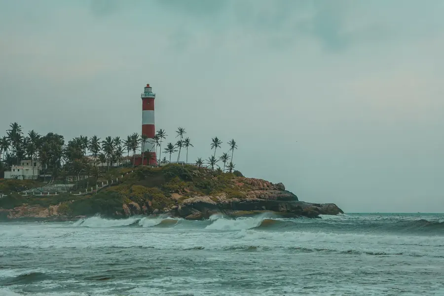 Kovalam lighthouse above the Arabian Sea with waves breaking on the shore, Kerala